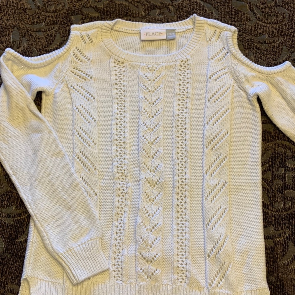 Cold shoulder ribbed crew neck sweater. Off with with silver shimmer.